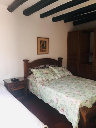 a bedroom with a bed and a night stand next to it at Casa Familiar Central Villa Diana in Villa de Leyva