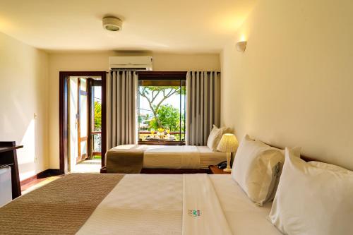 a hotel room with a bed and a balcony at Buzios Mar Hotel in Búzios