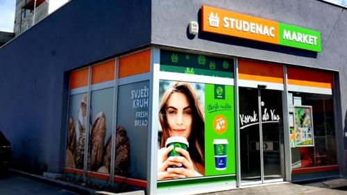 a store front with an advertisement for a drink at Apartments Vedrana in Ražanj