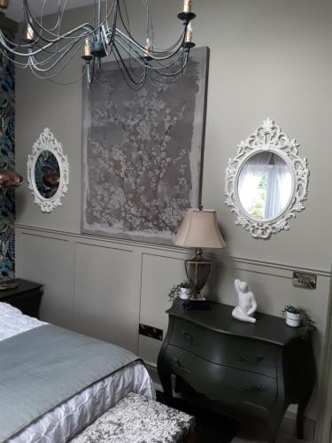 a bedroom with a bed and a mirror and a dresser at Ballybur Lodge Mews 1 in Kilkenny