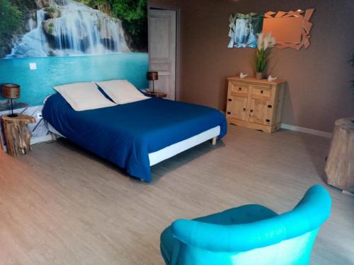a bedroom with a bed and a painting of a waterfall at Les escargots du mont in Tanis