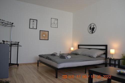 - une chambre avec un lit et deux lumières sur le mur dans l'établissement Sziget Apartman, à Eger