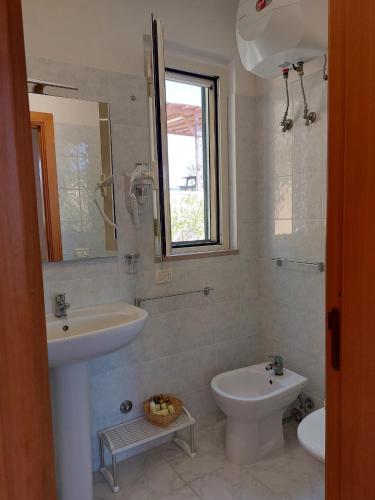 a bathroom with a sink and a toilet and a mirror at La Dimora dei Pescatori in Vieste