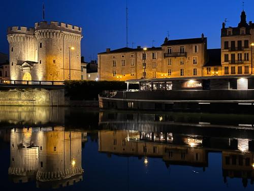 un château la nuit avec sa réflexion dans l'eau dans l'établissement Savy Hôtel, à Verdun-sur-Meuse