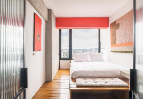 a bedroom with a bed and a large window at Good Hotel Guatemala City in Guatemala