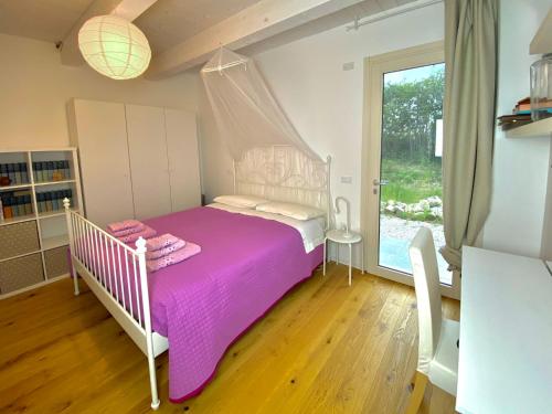 a bedroom with a pink bed with a canopy at Agriturismo - Apis in tabula in Ostra