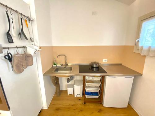 a small kitchen with a sink and a refrigerator at Agriturismo - Apis in tabula in Ostra