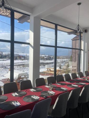 a conference room with a long table and chairs and a large window at Pensiunea CASA SPANDO in Mărişel