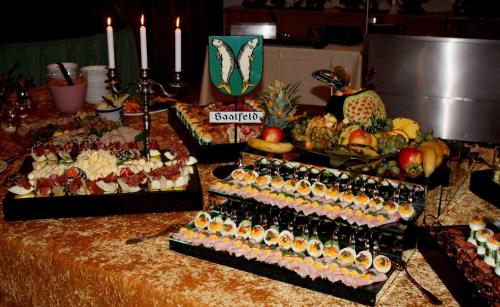 a buffet of food and drinks on a table with candles at Hotel & Restaurant Bergfried in Saalfeld