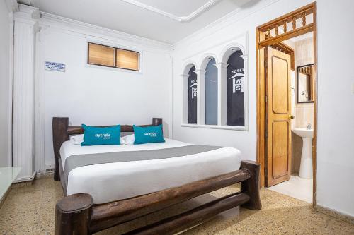 a bedroom with a bed with blue pillows on it at Ayenda William Sanchez in Apartadó