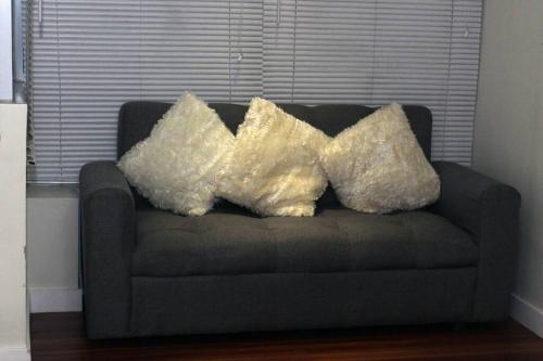 two pillows sitting on a couch in a living room at A2J BGC Luxury 2BR Loft Near Burgos Circle & Malls in Manila