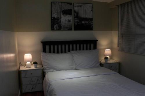 a bedroom with a bed and two night stands with lamps at A2J BGC Luxury 2BR Loft Near Burgos Circle & Malls in Manila