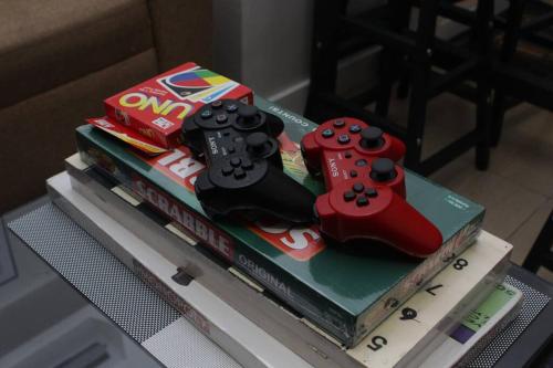 a cake with two video game controllers on top of books at A2J BGC Luxury 2BR Loft Near Burgos Circle & Malls in Manila