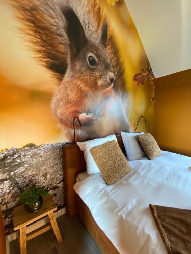 a bedroom with a painting of a squirrel jumping on a bed at Domestico Bed & Breakfast in Lage Mierde