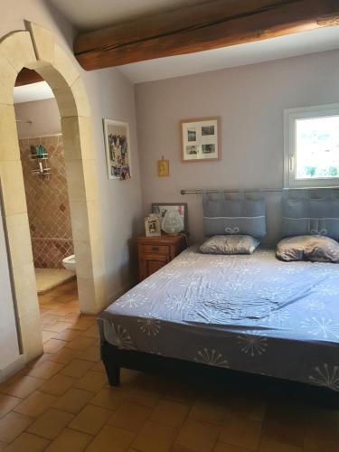 a bedroom with a blue bed and a shower at Villa L'Estagniol in Lourmarin