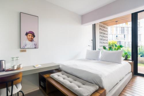 a bedroom with a bed and a desk and a window at Good Hotel Guatemala City in Guatemala