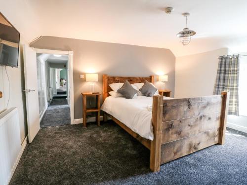 een slaapkamer met een groot bed met een houten hoofdeinde bij The Loft at The George in Chesterfield