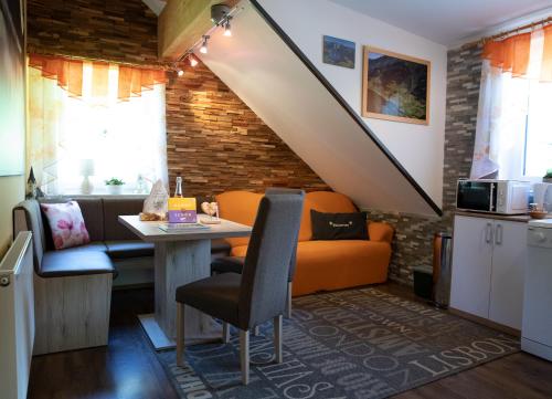 uma sala de estar com um sofá laranja e uma mesa em Appartement Edelweiss mit Infrarotkabine em Großsölk