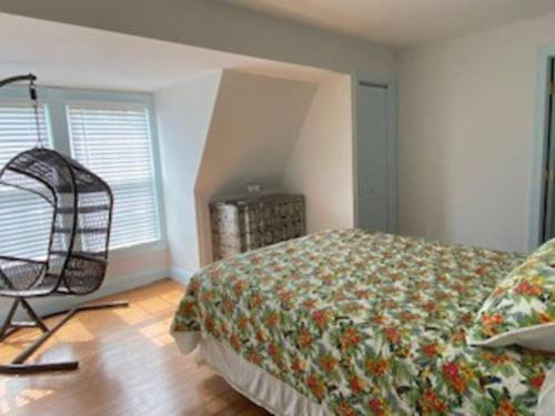 a bedroom with a bed and a chair in it at Saltwater Inn in Belmar