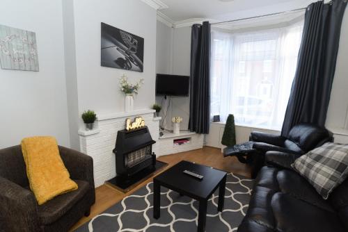 a living room with a couch and a fire place at Minshull House in Crewe