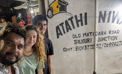 a group of people standing in front of a sign at Atathi Niwas Guest House for Backpackers and Travellers in Siliguri