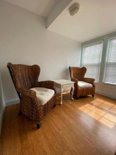 a living room with two chairs and a table at Saltwater Inn in Belmar