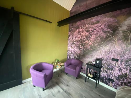 a room with purple chairs and a painting on the wall at Domestico Bed & Breakfast in Lage Mierde