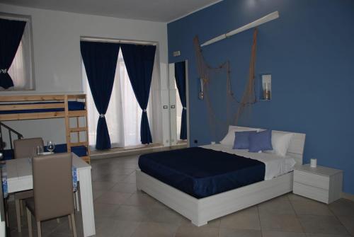 a bedroom with a bed and a blue wall at Four Seasons Summer Room in Cefalù