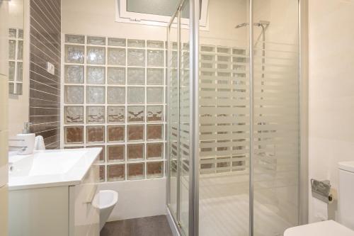 a bathroom with a shower and a toilet and a sink at Casa Avenida del Agujero in Gáldar