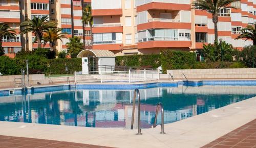 a swimming pool in front of a building at Apartamento frente al mar in Torrox Costa
