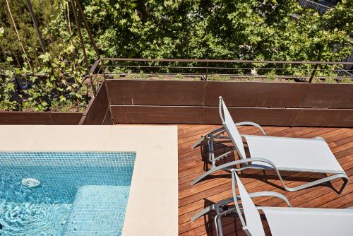 un patio con una mesa y una silla junto a la piscina en JOE'S GOMILA BOUTIQUE HOTEL en Palma de Mallorca