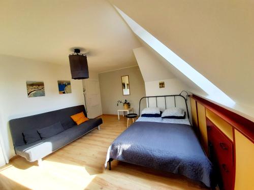 1 dormitorio con 1 cama y 1 sofá en el ático en Klimatyczne mieszkanie w Sopocie, en Sopot