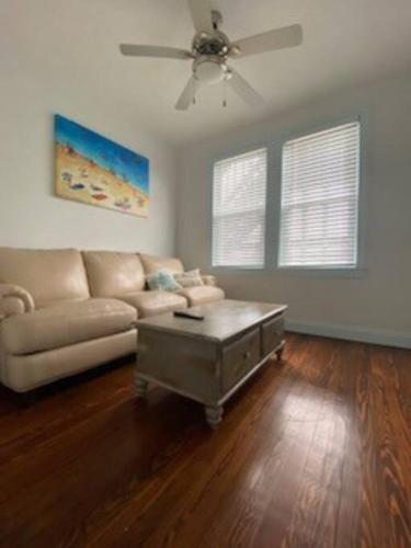 a living room with a couch and a ceiling fan at Saltwater Inn in Belmar