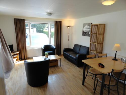 a living room with a couch and a table at Stellechalets op Vakantiepark Stelleplas - Heinkenszand in Heinkensand