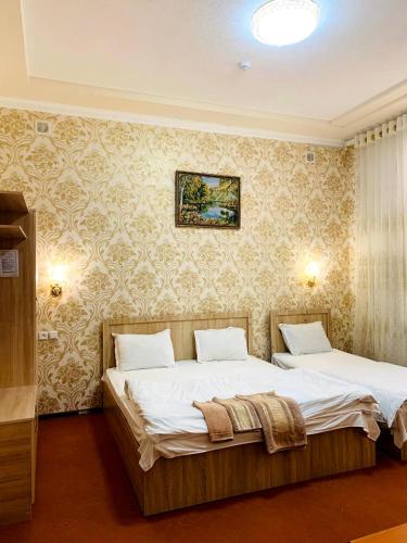 a bedroom with two beds and a painting on the wall at Зона отдых APACHI в горах ЧИМГАН in Chimgan
