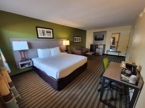 a hotel room with a large bed and a desk at Quality Inn Flamingo in Atlantic City