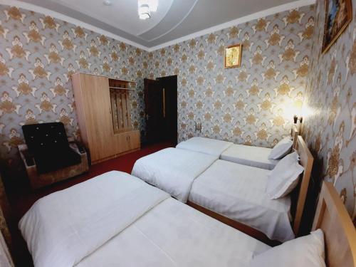 a room with three beds and a television in it at Зона отдых APACHI в горах ЧИМГАН in Chimgan