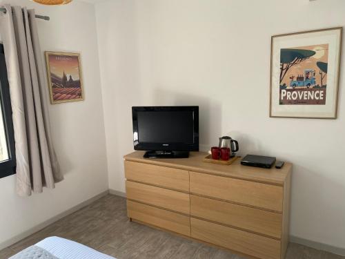a bedroom with a tv on a wooden dresser at Le domaine des Petits Princes in Lorgues
