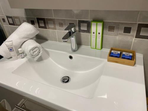 a white bathroom sink with a soap dispenser and towels at Le domaine des Petits Princes in Lorgues