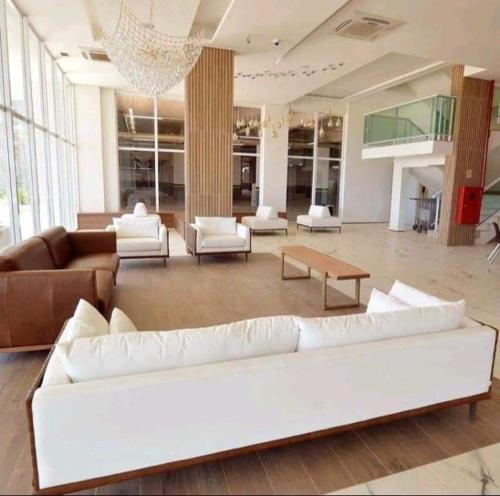 a large living room with white furniture and a chandelier at Salinas Resorts Exclusive, Premium e Park - Elcias Silva in Salinópolis
