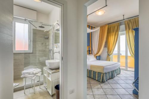 a bedroom with a bed and a sink and a shower at Hotel Albatros Varigotti in Varigotti