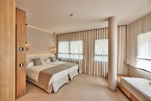 ein Schlafzimmer mit einem Bett und einem großen Fenster in der Unterkunft JOE'S GOMILA BOUTIQUE HOTEL in Palma de Mallorca