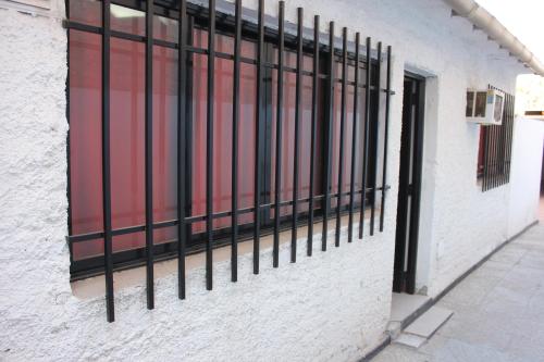 een raam met zwarte tralies aan de zijkant van een gebouw bij M I L I Departamento en Mendoza in Godoy Cruz