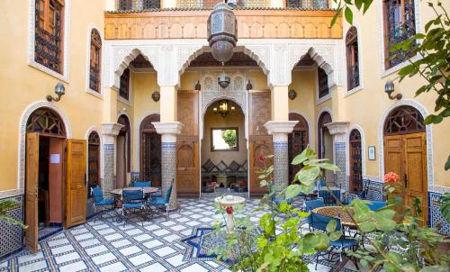 een binnenplaats met stoelen en tafels in een gebouw bij Riad Layalina Fes in Fès