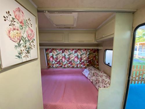 a camper with a pink floor and a bed in it at Sunny House Caravans in Sozopol