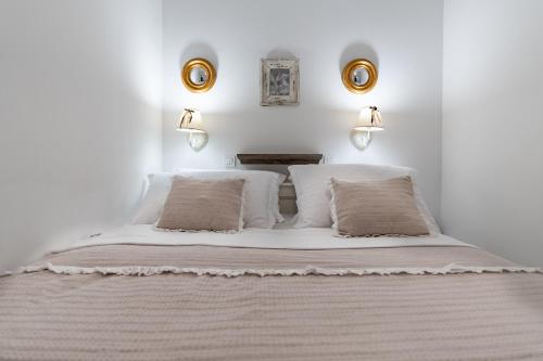 um quarto com uma cama grande com lençóis brancos e almofadas em Holiday Home - Villa Thorak em Anić