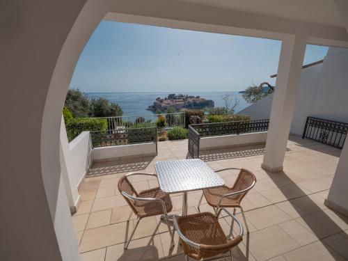 a patio with a table and chairs on a balcony at Vila Horizont in Sveti Stefan