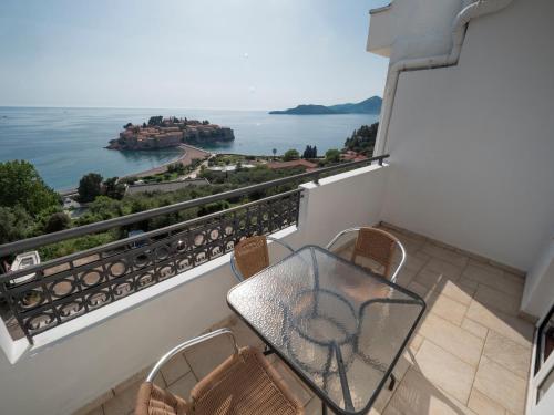 a balcony with a table and chairs and a view of the water at Vila Horizont in Sveti Stefan