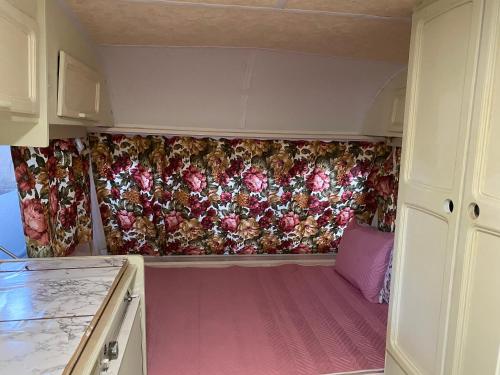 a small caravan with a curtain with flowers on it at Sunny House Caravans in Sozopol