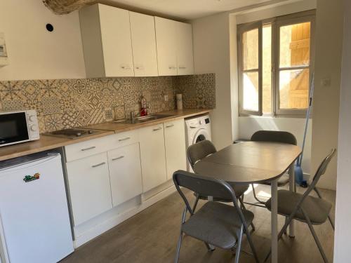 - une cuisine avec une table, une table et des chaises dans l'établissement Superbe studio plein cœur de ville, à Perpignan